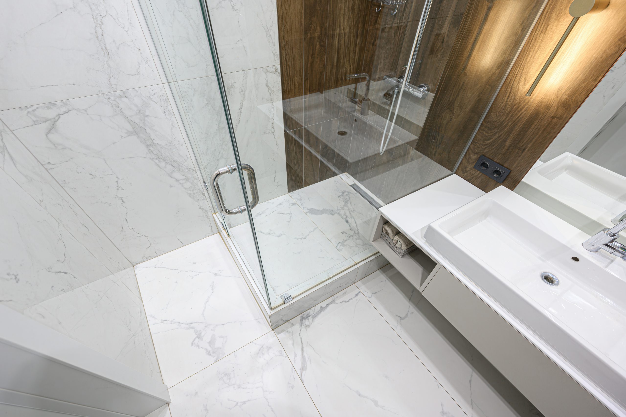 Frameless glass shower enclosure in a contemporary primary bath remodel