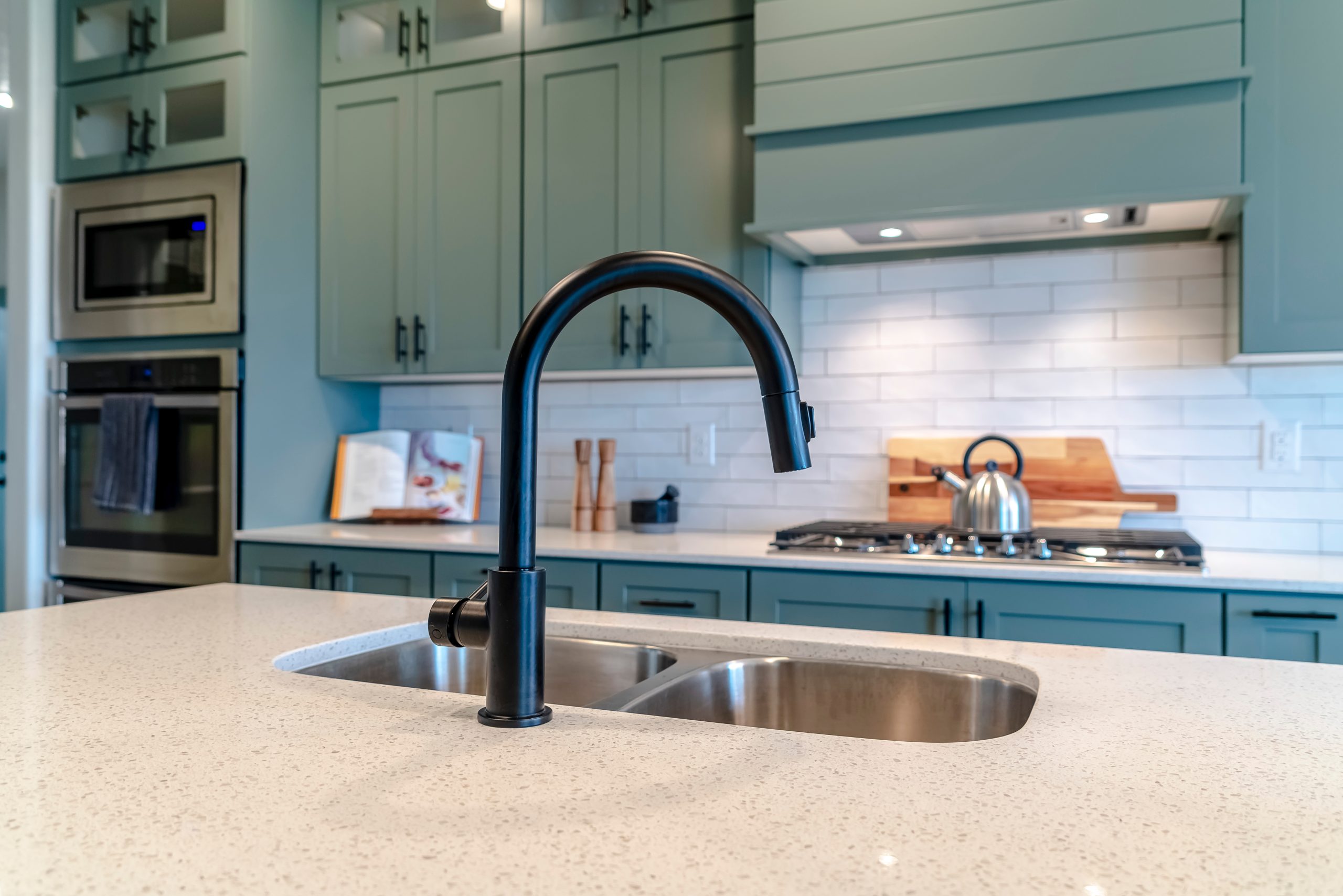Stainless steel double-bowl undermount sink set into a quartz kitchen island counter