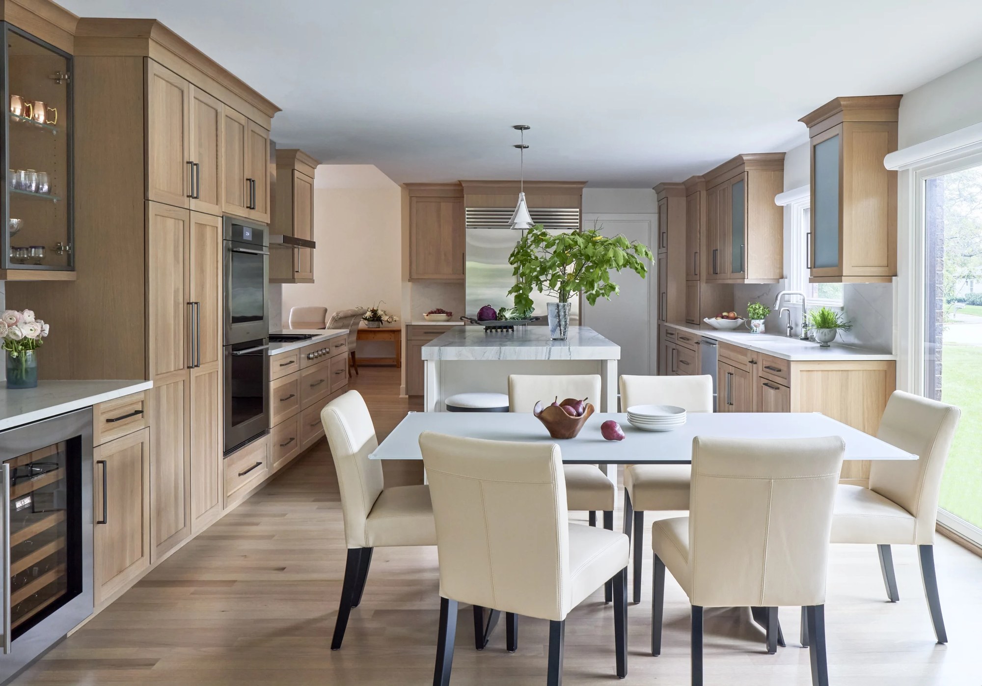 Northbrook kitchen with light wide-plank wood flooring running from the cabinetry through the adjoining dining area